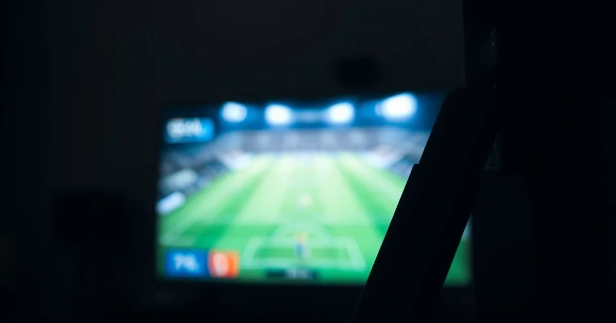 Une Fire TV Stick 4K Max branchée sur une télévision dans un salon sénégalais sombre et chaleureux, avec un match de football flou en arrière-plan.